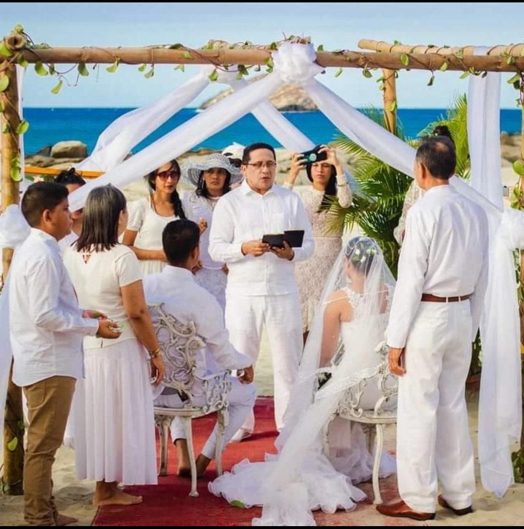 Ceremonia de boda con padrinos y novios a la orilla del mar