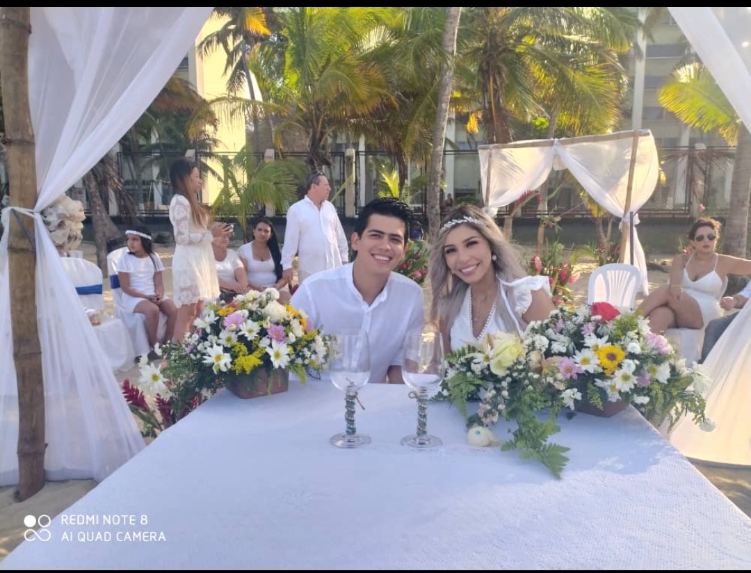 Novios en la mesa de honor de su boda en la playa